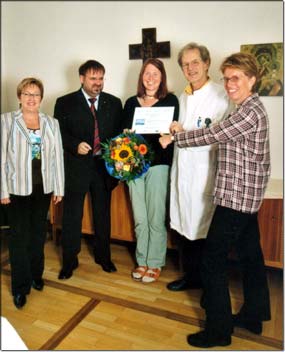 Freuen sich mit der Gewinnerin Anja Hitzler (Mitte): (v.l.) Rosemarie Schenk und Christian Schuster von der AOK, Chefarzt Dr. Helmut Boehm und stellvertretende Pflegedienstleitung Bettina Beyer-Lichtblau. &copy; KJF/Ruess