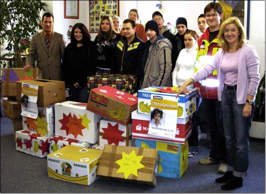 Der Schulleiter Elmar Eckert (links) und Lehrerin Ursula Sammer (rechts) mit ihren Sch�lern und den Paketen f�r den Weihnachtstruck. &copy; KJF