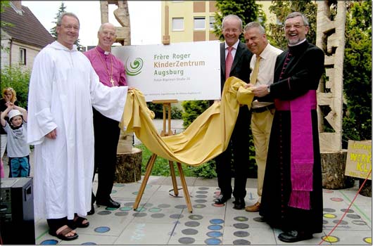 Das neue Schild f�r das Fr�re-Roger-Kinderzentrum enth�llten gemeinsam (von links) Fr�re Wolfgang, Regionalbischof Dr. Ernst �ffner, Regierungs-Vizepr�sident Josef Gediga und der Leiter des Jugendamts, Rudolf Nowak, sowie Jugendf�rsorge-Direktor Pr�lat G�nter Grimme. &copy; KJF/Karg